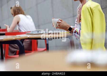 Personne buvant du café en plein air à la table du café Banque D'Images
