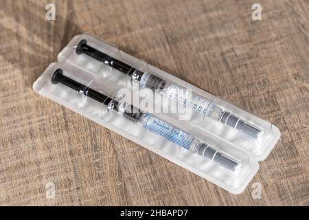 Un portrait d'un paquet contenant deux seringues sur une table en bois.Les injections de médicament sont faites d'un tube en verre avec des marques de volume sur lui un Banque D'Images