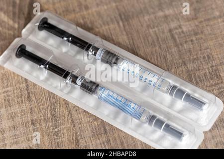 Un portrait d'un paquet contenant deux seringues sur une table en bois.Les injections sont faites d'un tube en verre avec des marques de volume sur lui un Banque D'Images