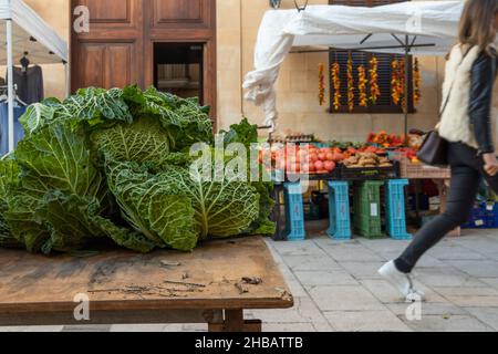 Gros plan d'un chou-fleur exposé au marché hebdomadaire de la rue dans la ville majorquine de Santanyi.En arrière-plan, hors de focus, le marché avec un Banque D'Images