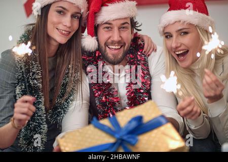 De jeunes amis avec des spamisseurs et des cadeaux en fête le jour de Noël Banque D'Images