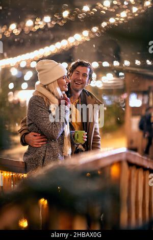 Homme et femme heureux appréciant au festival de noël sur un temps enneigé Banque D'Images