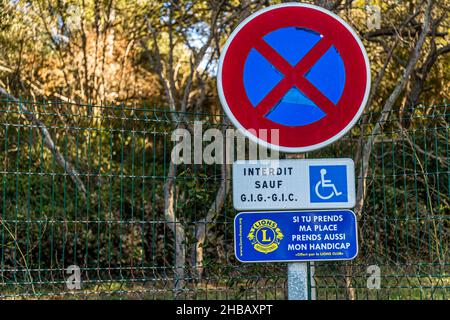 Parking réservé aux personnes à mobilité réduite.Un signe mis en place par le Lions Club dit: Si vous prenez ma place, prenez aussi mon handicap.Bormes-les-Mimosas, France Banque D'Images