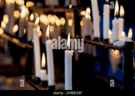 Religion fond avec bougies blanches allumées sur la cheminée à l'église. Banque D'Images