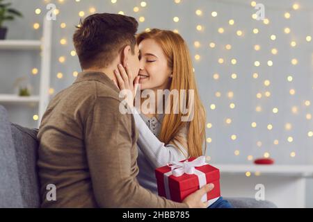 Jeune couple heureux en amour embrassant pendant les cadeaux et les fêtes de fête Banque D'Images