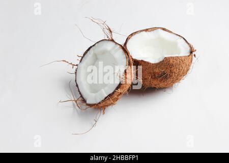 Deux moitiés de noix de coco hachée sur fond blanc Banque D'Images