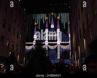 17 décembre 2021, New York, New York, États-Unis : 18 décembre2021 New York, Rockefeller Center arbre de Noël allumé la nuit tandis que les patineurs jouent sur la glace.Un magnifique spectacle de lumière est projeté sur l'avant du grand magasin 'Saks Fifth Ave. (Image de crédit : © Bruce Cotler/ZUMA Press Wire) Banque D'Images