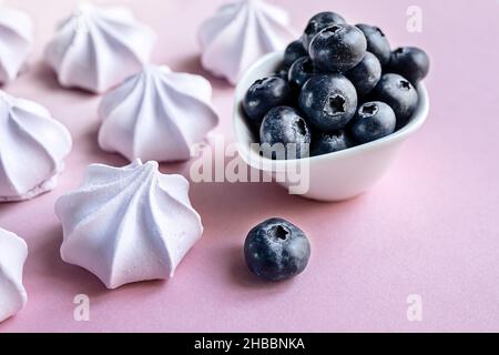 Petits gâteaux de meringue aux baies françaises ou guimauve et bleuets dans l'assiette sur la table en gros plan Banque D'Images