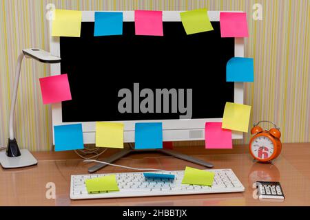 Lieu de travail.Sur le moniteur, autocollants vierges multicolores pour la planification, lampe, réveil, clavier sur la table à la maison.Lieu de travail indépendant. Étudiant de Banque D'Images