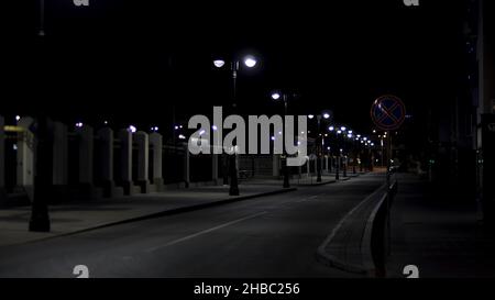 Belle et calme atmosphère de la nuit d'été dans la grande ville, rue sombre avec beaucoup de lanternes brillantes.Route et trottoir vides. Banque D'Images