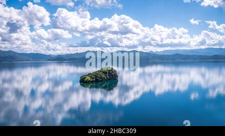 Paysage du lac Lugu avec un rocher en lui sous un ciel bleu nuageux dans le Sichuan, Chine Banque D'Images