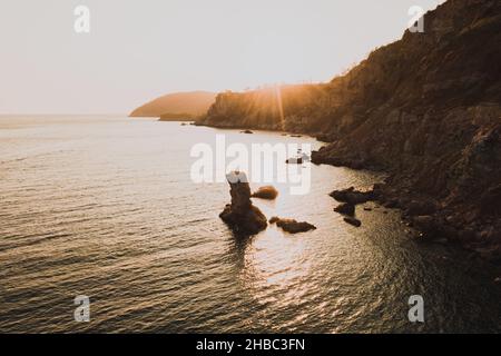 Vue aérienne en soirée drone au-dessus de la mer Adriatique au Monténégro. Vue panoramique sur la montagne marine ensoleillée. Papier peint été nature. Roche d'eau sombre et calme Banque D'Images