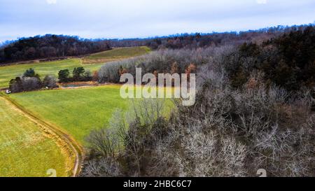 Flanc de colline dans le Wisconsin rural bluffs avec des champs verts en dessous.Un petit vignoble peut être la scène sur la colline loin. Banque D'Images