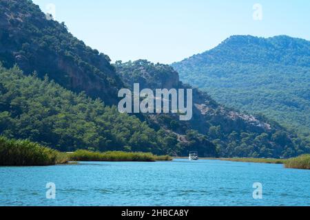 Bateau de plaisance touristique sur la rivière Dalyan, à côté des rochers, qui contiennent les tombes lyciennes, dans la province de Mugla, Turquie Banque D'Images