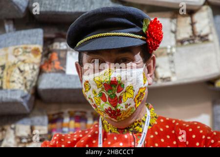 Moscou, Russie.18th décembre, 2021 le vendeur portant un masque de protection montre des nappes avec un modèle national russe sur le comptoir à l'exposition-salon de l'artisanat folklorique de Russie 'Ladya' à l'Expocentre de Moscou, Russie Banque D'Images