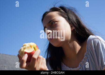 Une fille de 11 ans mangeant une pomme Banque D'Images