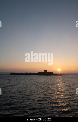 Lever de soleil en hiver au-dessus du fort de St Aubin, Jersey, îles Anglo-Normandes, orientation portrait. Banque D'Images