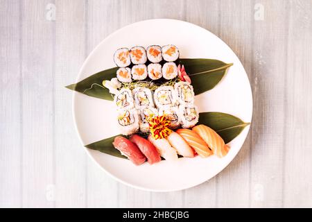 Assortiment de sushis ronds avec maki, hosomaki, suramaki de californie, nigiri et assortiment de pousses de haricots, thon rouge, saumon norvégien, algues de nori, an Banque D'Images