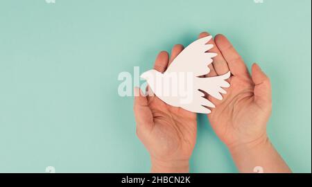 Tenant une colombe blanche entre les mains, symbole de paix, découpe de papier, espace de copie pour le texte Banque D'Images