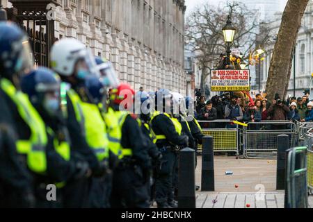 Londres, Royaume-Uni.18th décembre 2021.Un protestant tient un écriteau qui dit «Boris Johnson F. vous et vos politiques nazies.Emprisonner le gouvernement menteur pour crimes contre l'humanité.» pendant la manifestation.Suite à l'annonce du Premier ministre britannique Boris Johnson sur la mise en œuvre de passes à vide et du Plan C, qui mettra en place des blocages partiels, les anti-vaxxers s'évertue à Downing Street en fureur.Les manifestants se sont affrontés avec la police.Crédit : SOPA Images Limited/Alamy Live News Banque D'Images