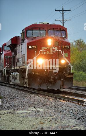 Bartlett, Illinois, États-Unis.Une paire de locomotives du chemin de fer canadien Pacifique conduisent un train de marchandises sous la pluie peu avant la tombée de la nuit. Banque D'Images