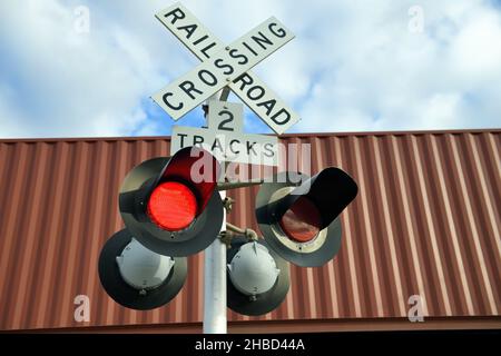 Hoffman Estates, Illinois, États-Unis.Signaux clignotants à un passage à niveau de chemin de fer protégé par l'appareil ainsi que par une grille de garde-corps descendante. Banque D'Images