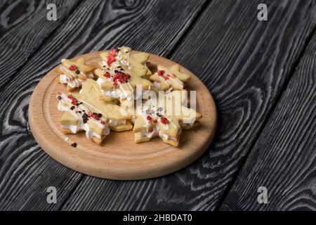 Sandwiches guimauves décorés de chocolat et de fraises lyophilisées.Couchez-vous sur une planche ronde en bois.Gros plan. Banque D'Images