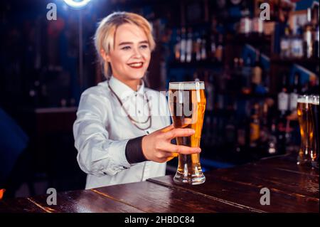 Un barman concocte un cocktail derrière le bar Banque D'Images