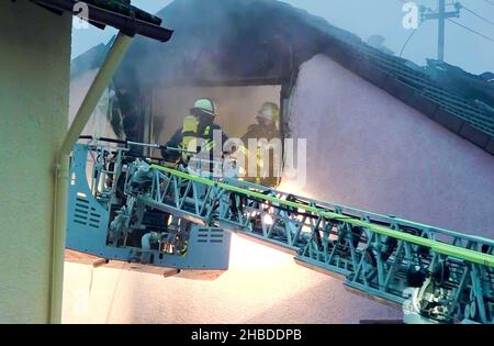 Bade-Wurtemberg, Allemagne.19 décembre 2021, Bade-Wurtemberg, Neuenstadt am Kocher: Les pompiers entrent dans un grenier par une échelle de plateau tournant.Deux personnes sont mortes dans le feu d'un appartement mansardé dans le quartier de Heilbronn.Deux enfants peuvent avoir été impliqués.Trois résidents de l'édifice, âgés de 29, 27 et 8 ans, ont également été grièvement blessés dans l'incendie.Photo: Leonard Buchner Einsatz-Report24/dpa crédit: dpa Picture Alliance/Alay Live News Banque D'Images