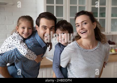 Portrait de tête de prise de vue heureux parents piggy soutenant les petits enfants Banque D'Images