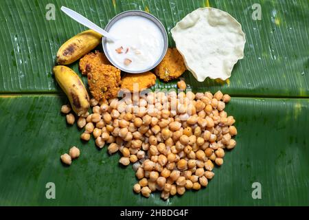 Dans les festivals traditionnels d'Asie du Sud (Indien), la feuille de banane est servie avec le sundal végétarien de pois chiches, le masala vada, les bananes, le papayasam et le lait. Banque D'Images