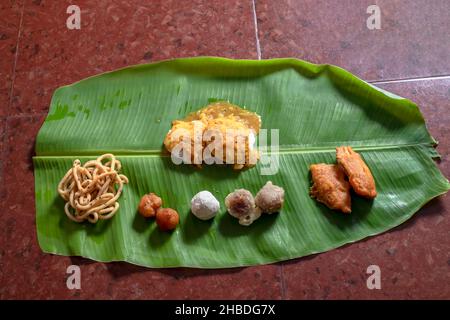 Plat traditionnel servi sur une feuille de banane le jour du festival indien.Il est servi le petit-déjeuner au festival de Diwali. idli sambar, doux et alcalin. Banque D'Images