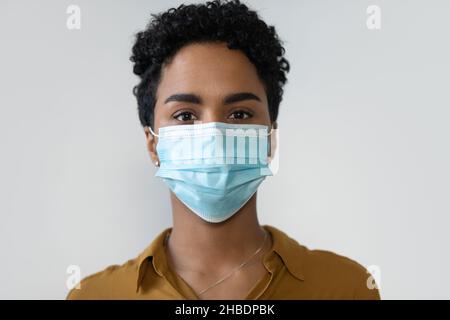 Portrait en tête d'une femme afro-américaine sérieuse en masque de visage. Banque D'Images