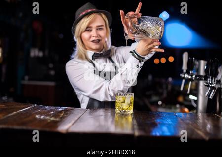 Un barman concocte un cocktail derrière le bar Banque D'Images