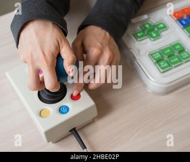 Femme atteinte de paralysie cérébrale travaille sur une souris informatique spécialisée. Banque D'Images