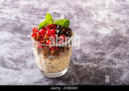 Un verre avec différents raisins de Corinthe sur la table.Raisins de Corinthe frais et feuilles de menthe.Vue de dessus. Banque D'Images