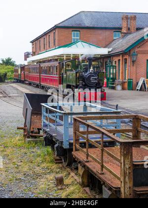 Un train attend à la gare de Tywyn Wharf au chemin de fer de Talyllyn, Gwynedd, pays de Galles. Au premier plan sont les camions qui ont été utilisés pour le transport des lattes Banque D'Images