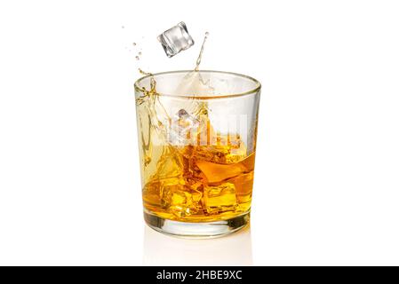 Verre de Whiskey, whisky ou bourbon avec glaçons tombant avec éclaboussures, isolé sur blanc Banque D'Images