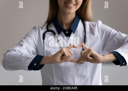 Gros plan de la jeune femme médecin faisant le coeur des doigts Banque D'Images