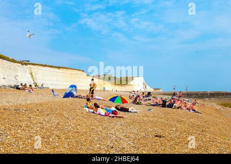 Les gens se détendent et bronzer sur une plage de galets à Saltdean, East Sussex, Royaume-Uni Banque D'Images