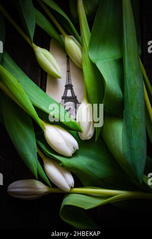 Tulipes blanches sur une table avec une photo de la Tour Eiffel Banque D'Images