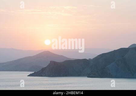 Vue sur la mer et les montagnes.Soirée d'été au bord de la mer.Coucher de soleil dans des tons pastel doux.Arrière-plan naturel pour le placement du texte Banque D'Images