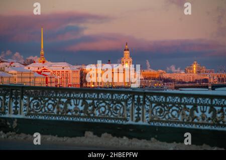 Vue panoramique d'hiver de Saint-Pétersbourg au coucher du soleil, flèche dorée de la forteresse Pierre et Paul, tour de Kunstkamera, remblai avec pont sur fond Banque D'Images