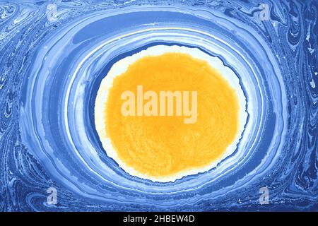 Un arrière-plan abstrait avec des cercles de peinture à l'huile jaune et bleu Banque D'Images