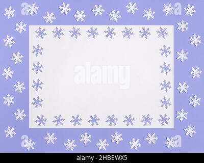 Maquette de Noël avec flocons de neige sur fond violet.Couleur de l'année 2022 très Peri.Espace pour le texte.Carte de vœux.Concept d'hiver. Banque D'Images
