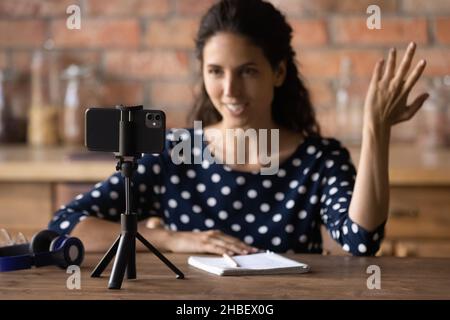 Femme souriante agréable influenceur enregistrant la vidéo sur un smartphone. Banque D'Images