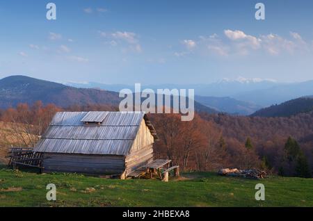 Paysage du soir avec une maison en bois dans les montagnes.Soirée de printemps.Carpates, Ukraine Banque D'Images