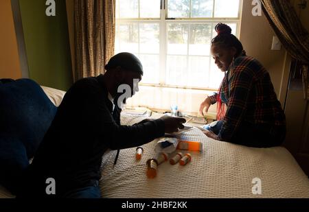 Smyrna, Géorgie, États-Unis.19th décembre 2021.Genetra Quick aide son mari Robert à trier ses médicaments dans l'hôtel de séjour prolongé près d'Atlanta où ils vivent avec trois filles du collège.« ItÃs tout ce que nous pouvons nous permettre, » et nous sommes suspendus par de minces fils et prières », a déclaré Quick, 36, qui livre des repas aux clients Uber Eat, travaillant 14-16 heures par jour.Son mari a reçu un diagnostic de pancréatite sévère et d'autres problèmes abdominaux qui limitent sa capacité à travailler.« il reste avec les filles pendant que je travaille », a-t-elle dit.La famille est au bord de l'itinérance, survit au quotidien dans le Banque D'Images