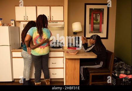 Smyrna, Géorgie, États-Unis.19th décembre 2021.Genetra Quick, son mari handicapé Robert, et trois enfants adolescents vivent de jour en jour dans un hôtel pour séjour prolongé au nord d'Atlanta.La famille est financièrement à court et sans transport pour être en mesure de travailler quand son camion a été repris, parce que le besoin de crédit d'impôt fédéral pour enfants n'a pas pu arriver à temps.Photo : Genetra prépare le dîner et discute avec les filles (Credit image: © Robin Rayne/ZUMA Press Wire) Banque D'Images