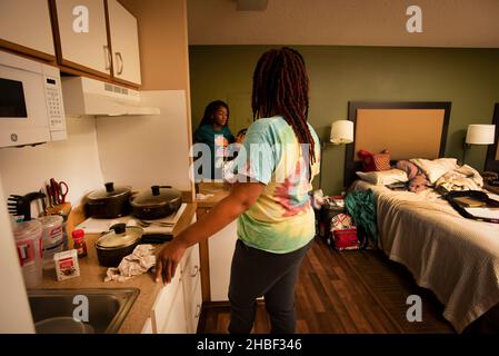 Smyrna, Géorgie, États-Unis.19th décembre 2021.Genetra Quick, son mari handicapé Robert, et trois enfants adolescents vivent de jour en jour dans un hôtel pour séjour prolongé au nord d'Atlanta.La famille est financièrement à court et sans transport pour être en mesure de travailler quand son camion a été repris, parce que le besoin de crédit d'impôt fédéral pour enfants n'a pas pu arriver à temps.Photo : Genetra prépare le dîner et discute avec les filles (Credit image: © Robin Rayne/ZUMA Press Wire) Banque D'Images